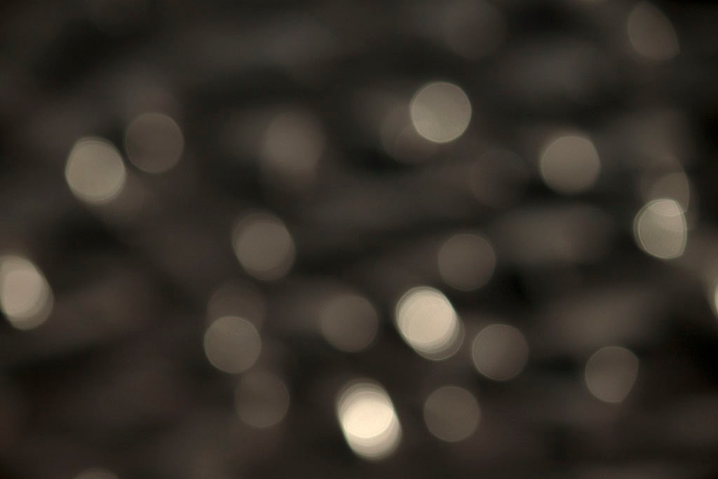 Depoe Bay, OR 2017 — dark silver bokeh, sparse large light orbs on near-black background