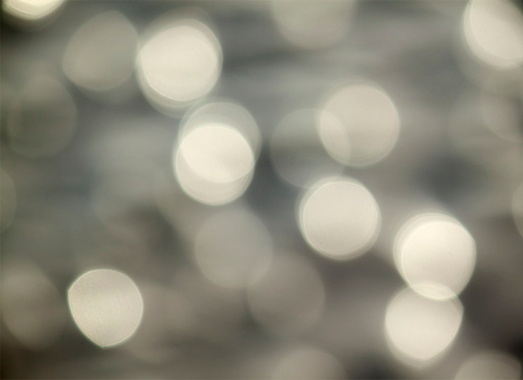 Depoe Bay, OR 2017 — soft silver bokeh, large diffuse orbs on pale grey background
